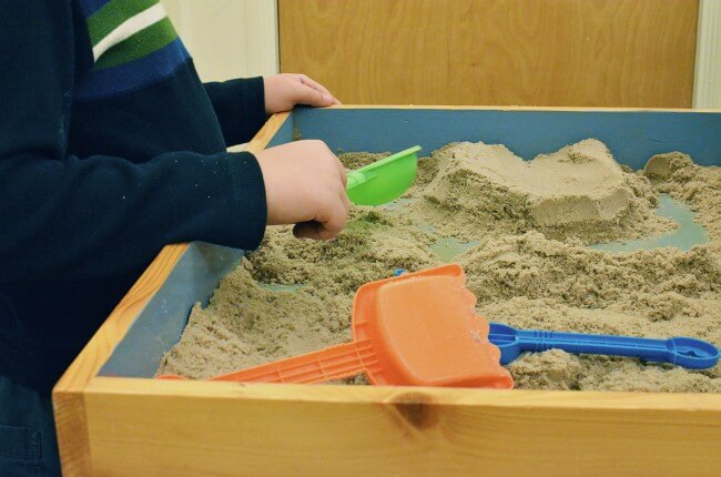 Child doing play therapy in sand tray